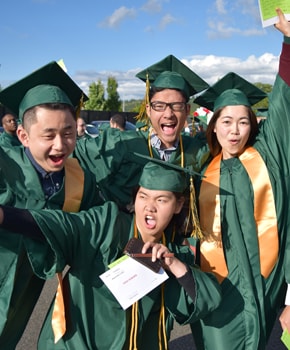 photo of Green River College students in graduation caps and gowns celebrating