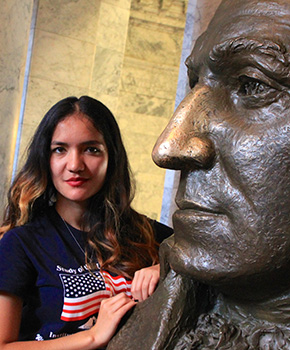 SUSI 2015 participant posing with statue of George Washington at Olympia Capitol Building