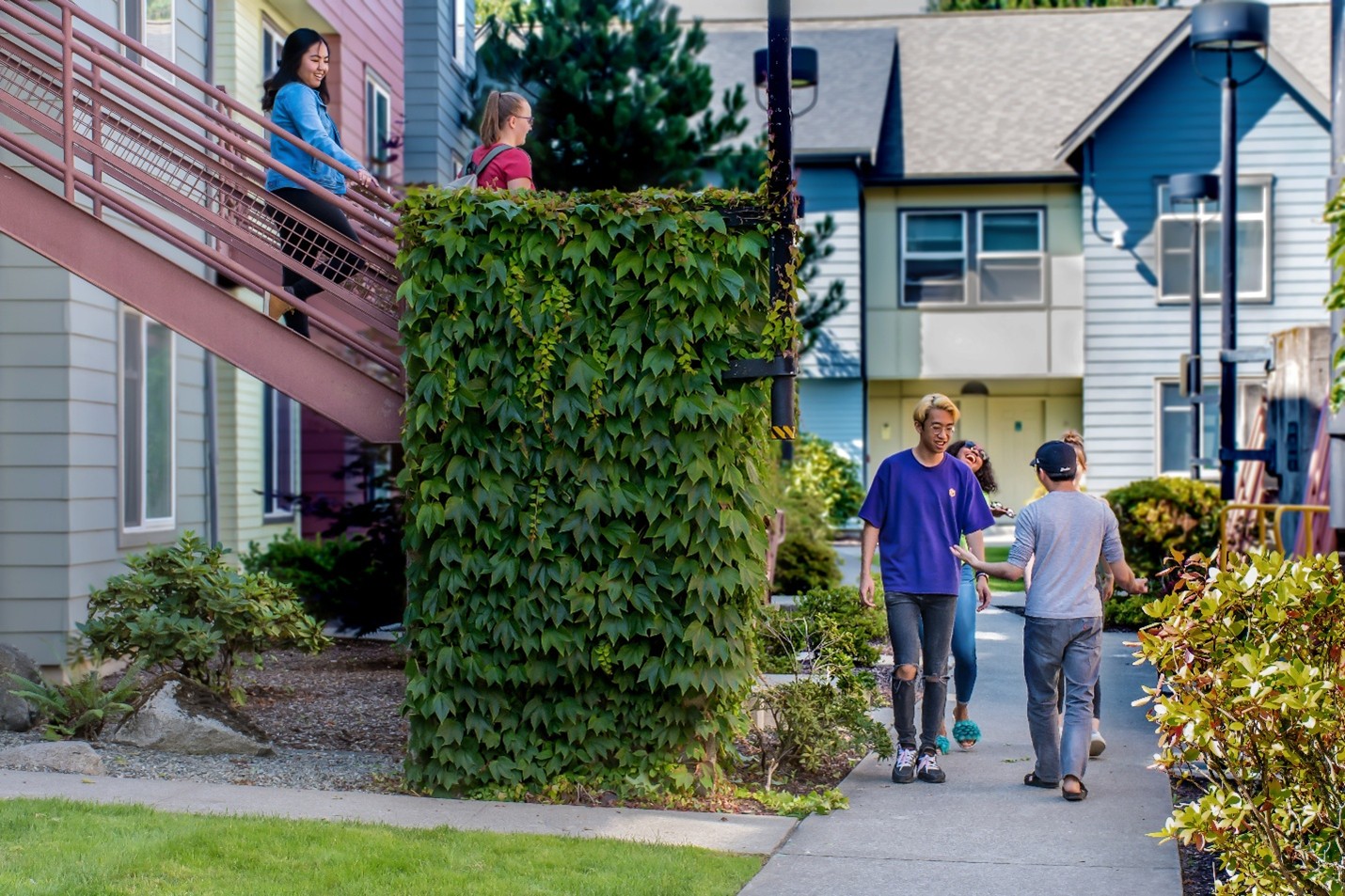six students walking around the student housing paths