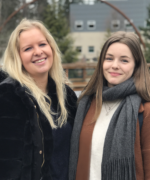 Amalie Knudsen and Emilie Rasmussen standing in front of the fountain on Green River College campus.