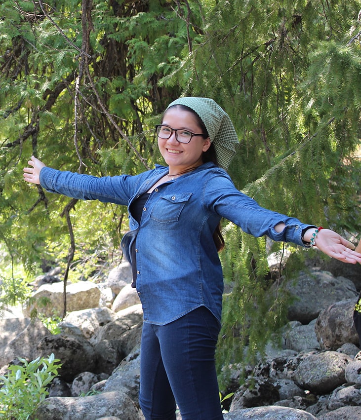 Feruza standing among trees during her visit to the USA.