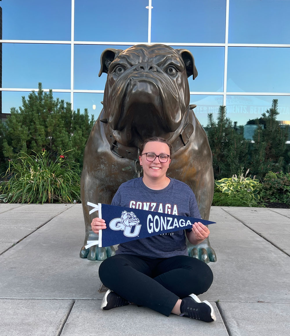 Naomi van Roon holding the Gonzaga banner in front bulldog mascot