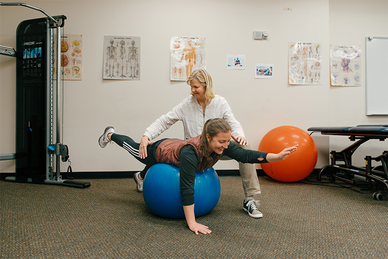 PTA staff with patient on ball
